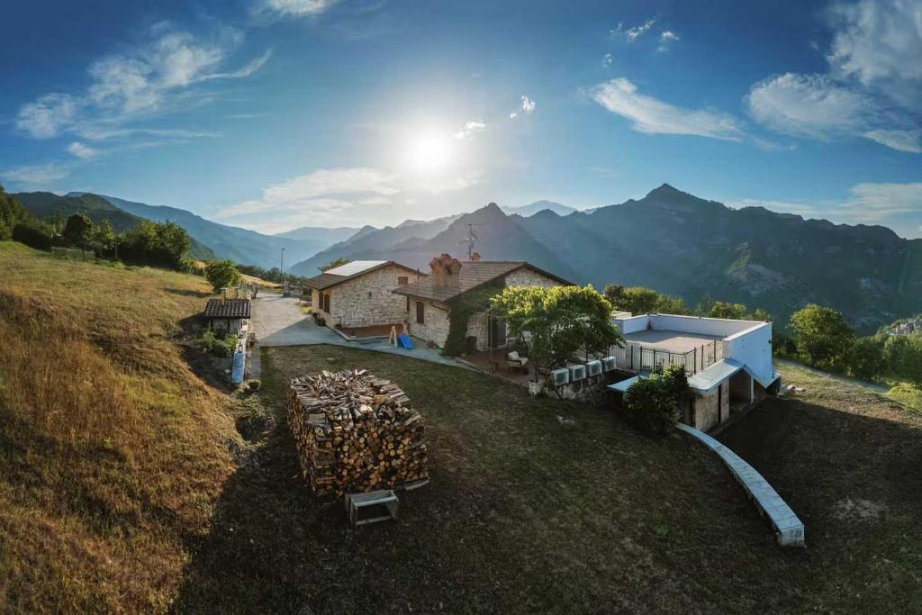 Catasta di legna nel prato accanto al casale con panorama montano